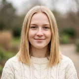 Young woman with straight blonde hair in a cream knit sweater